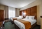 Comfort Suites Appleton Airport - A standard room with two double beds includes a flat screen TV, desk, coffee maker, refrigerator, microwave, hair dryer, sleeper sofa, iron, and ironing board.