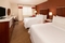 Four Points Sheraton Boston Logan Airport - A Marriott Family Brand Hotel - Guest room with 2 double plush beds and comfortable armchair seating.