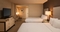 Hilton Los Angeles International Airport - The standard room with two double beds includes a standard desk, chair, alarm clock radio with MP3 connection, coffeemaker, iron, ironing board, and a marble bathroom with hair dryer.
